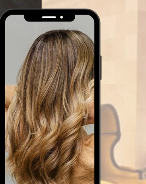 Ansicht einer Langjahrfrisur von hinten. Die hellbraunen Haare fallen in weichen Wellen